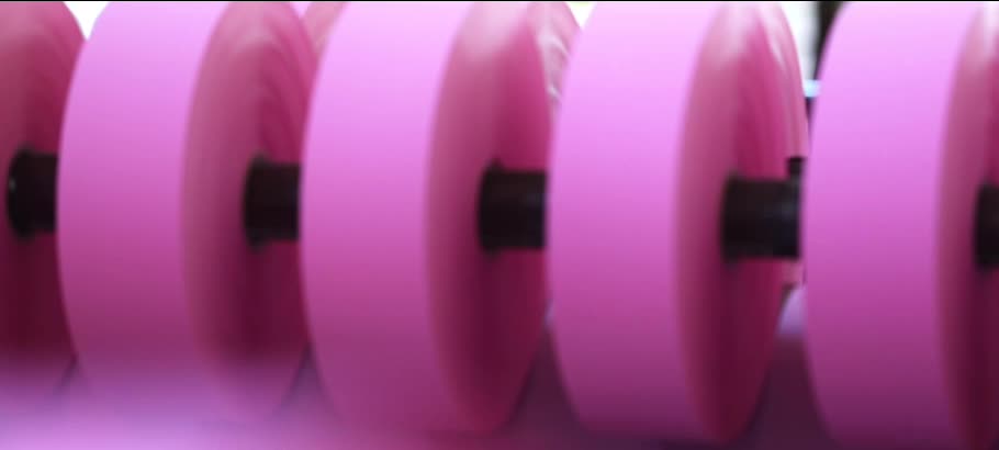 A row of pink Aolong vegetable parchment paper rolls on the production shaft